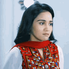 a woman with a red scarf around her neck is wearing a white shirt