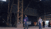 a man and a woman are standing in a warehouse with a banner flying in the background that says ' go ' on it