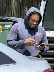a man wearing a blue sweatshirt with the word spot on the front