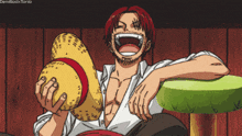 a man with red hair is holding a hat and smiling
