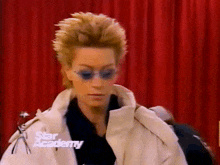 a woman wearing sunglasses and a white jacket with the words star academy on the bottom