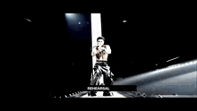 a man in a white shirt is standing in a dark room with the words rehearsal above him