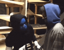 a man in a blue mask is standing next to another man