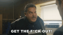 a man says get the f * ck out while standing in front of a window