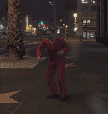 a man in red pants is dancing in front of a star