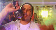 a man is singing into a microphone while wearing a white shirt