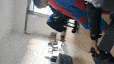 a person in a spiderman costume is holding a vase