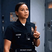 a woman in a police uniform is giving a warning and saying do not start .