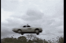 a police car is flying through the air .