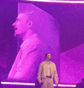 a man stands in front of a large purple screen