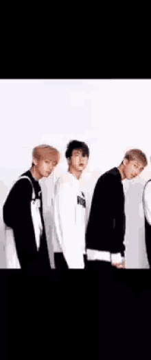 a group of young men standing next to each other on a white background .
