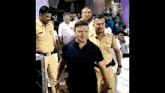 a group of police officers are standing around a man .