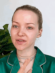 a close up of a woman 's face with a green shirt on
