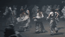 a group of women in white clothes are dancing