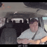 a man in a white shirt and purple hat is driving a car .