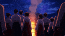 a group of people in kimonos are standing around a fire