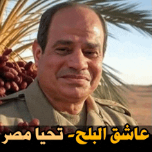 a man in a tan jacket stands in front of a palm tree