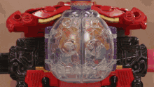 a red toy with a clear container that says ' over ' on it