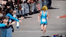 a runner with a duck on his head is being greeted by a crowd .