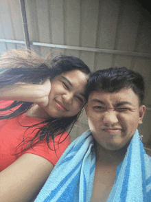a man and a woman are posing for a picture with a towel wrapped around their necks