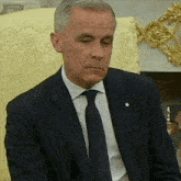 a man in a suit and tie sitting in a chair