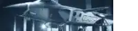 a fighter jet is parked in a hanger in a building .