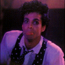 a man wearing a polka dot vest and tie is making a face