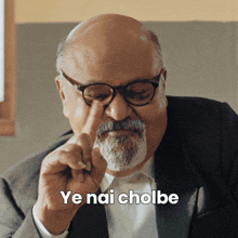 a bald man with glasses and a beard says ye nai cholbe with his finger on his nose