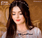 a woman wearing a white dress and a headband is looking down .