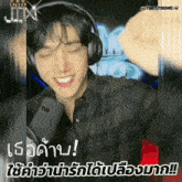 a man wearing headphones and a t98 microphone smiles