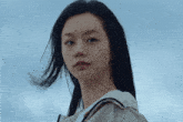 a close up of a woman 's face against a blue sky