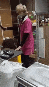 a woman wearing a mask and gloves is standing at a counter