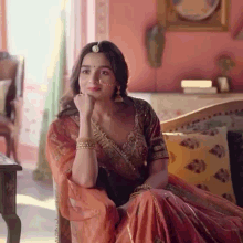 a woman in a traditional dress is sitting on a couch