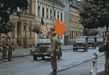 a man in a military uniform stands in front of a jeep with an american flag on top