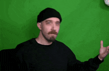 a man with a beard is wearing a black hat and a black shirt