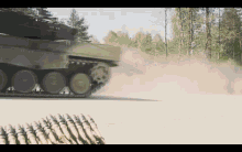 a tank is driving down a dirt road with a pile of bullets in the foreground