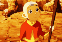 a young boy in a red and yellow outfit is holding a stick