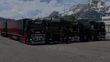 a row of black and red scania trucks parked in a parking lot