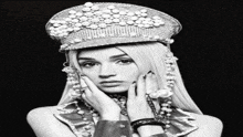 a woman wearing a hat with pearls and rhinestones