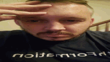 a man with a beard wears a black shirt that says " flowmajion " on it