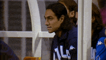 a man wearing a kappa sweatshirt looks at something