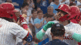 a baseball player with the letter p on his helmet is being hugged by another player