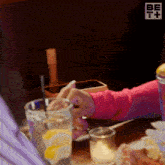 a person sitting at a table with a glass of lemonade and a cell phone