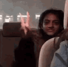 a woman is sitting in the back seat of a car and making a funny face .