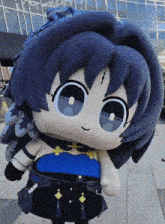 a stuffed doll with blue hair and a black skirt