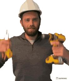 a man in a hard hat is holding a drill and pliers