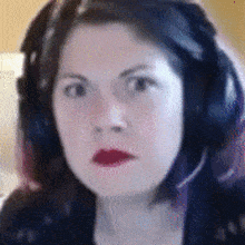 a close up of a woman wearing headphones and red lips