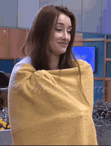 a woman is wrapped in a yellow blanket with the word bette on the bottom right