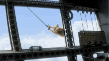 a cartoon character is hanging from a rope in a window
