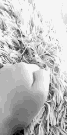 a black and white photo of a person laying on a blanket .
